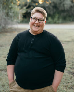 Photo of guest blogger Lex Vriend, a fat person smiling with grass and trees in the background.