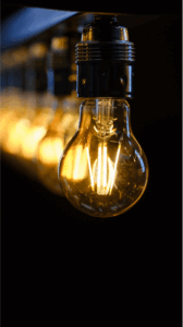 A row of lit lightbulbs against a dark backgroun,